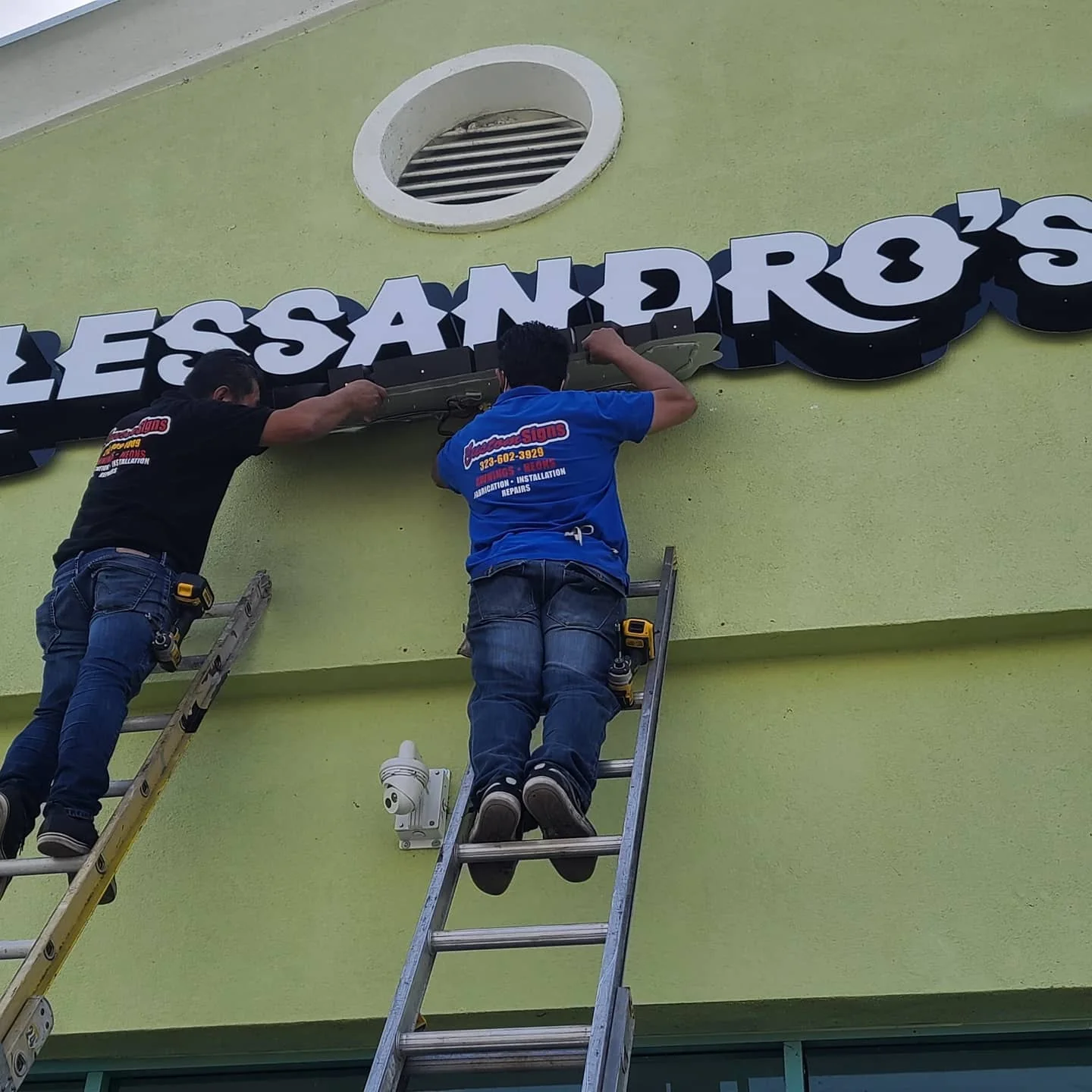 Crew installing Alessandro's sign